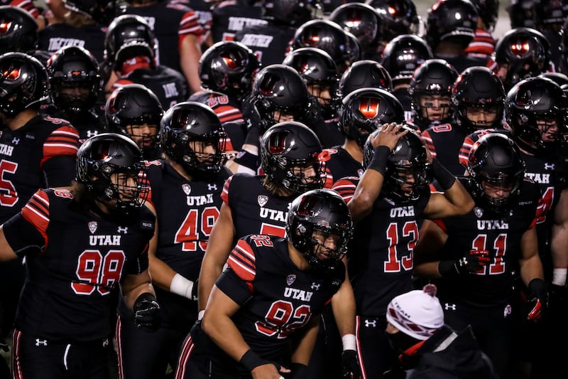 Utah Utes players gather on the field.
