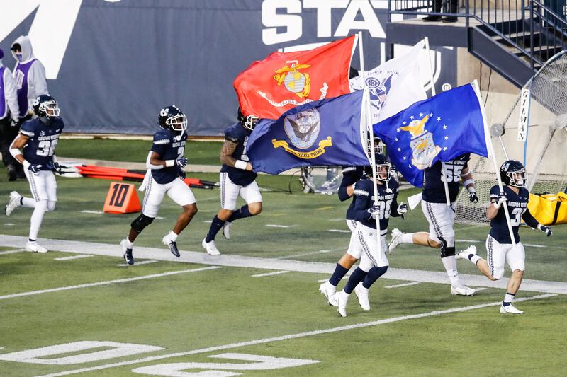 Utah State Aggies football players run onto the field at Maverik Stadium in Logan, Utah.
