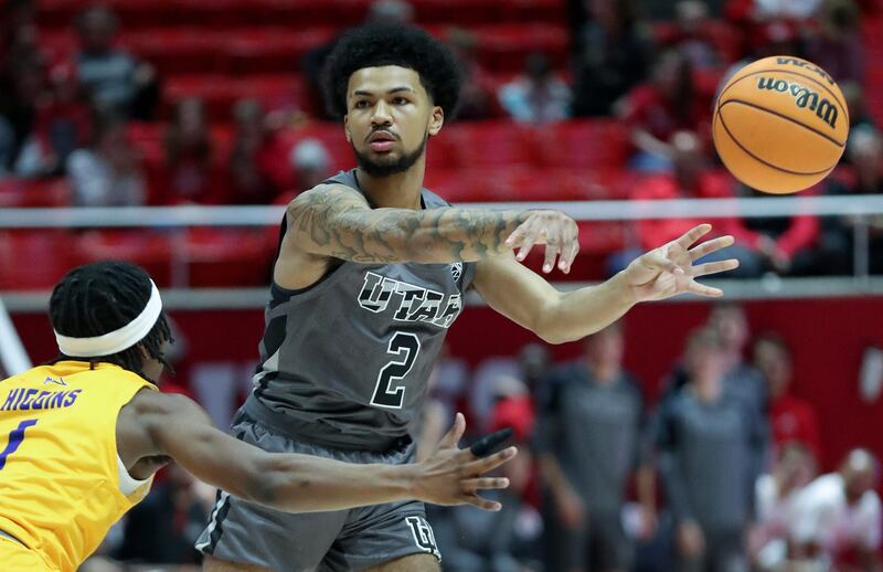 Utah Utes guard Mike Saunders Jr. (wearing grey) passes the ball