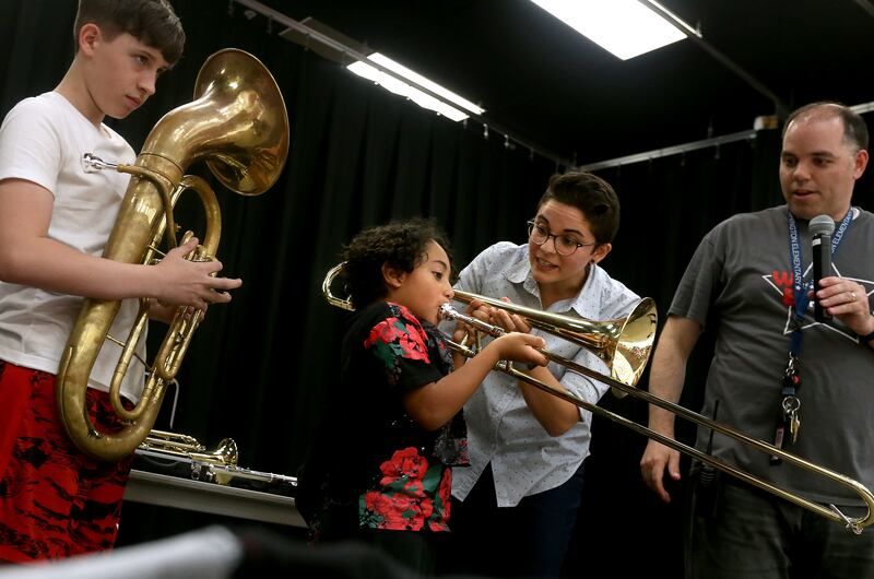 Anthony Salazar holds a euphonium while Andre Madrid tries to play a trombone with music specialist Abbie Trevino and Jason Finch, assistant principal at Washington Elementary School, in Salt Lake City on Thursday, May 30, 2019. The school received a dona
