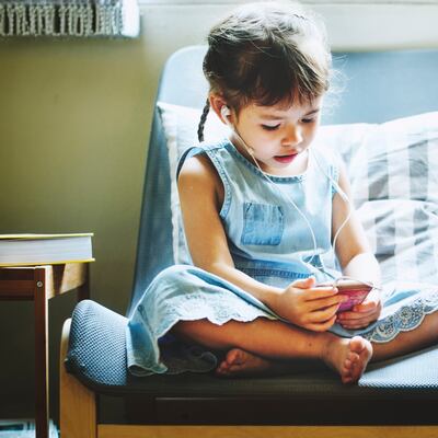 A child using a smartphone, listening to earbuds. "Connect," a new film hosted by actor Kirk Cameron, examines the impact that technology has on its young users and screens Tuesday and Wednesday, Feb. 27 and March 1.