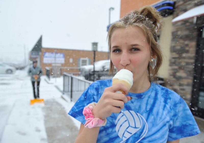 A Westmont High School student enjoys a free ice cream cone from the Westmont Dairy Queen location in Johnstown, Pennsylvania, as snow falls on the first day of spring, Tuesday, March 20, 2018. The Dairy Queen Corporation was giving out one free cone per
