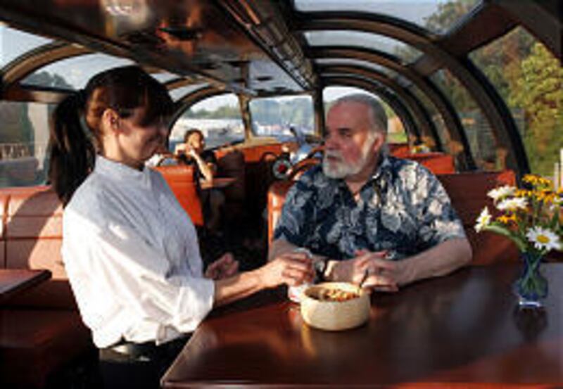 Ted Hutton is served by Connie Dixon in Cincinnati inside a private-car train that includes a Vista Dome sleeper-lounge topped with a glass dome providing a 360-degree view of the surroundings.