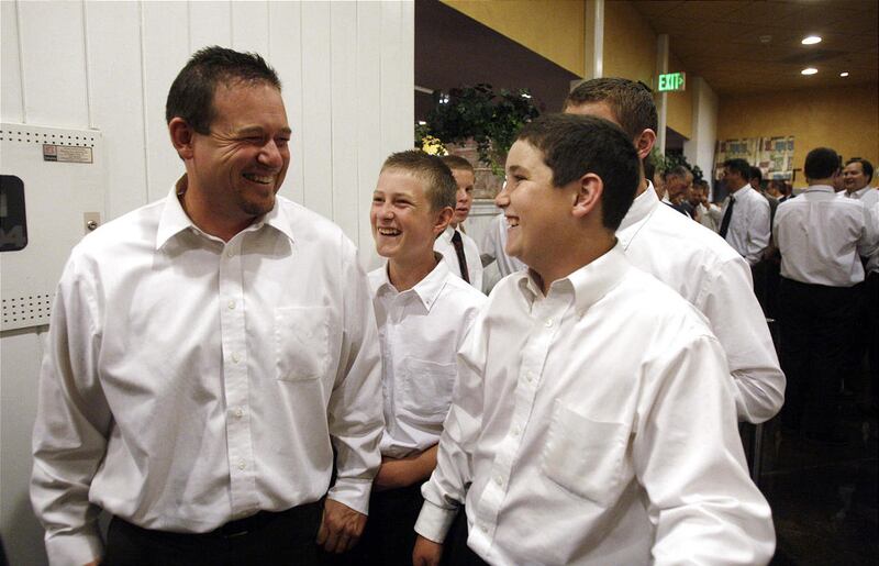 Jesse Burrell laughs with his sons Bo, Braydon and Caden while waiting in line at Chuck A Rama after attending LDS General Conference Priesthood session in Salt Lake City Saturday, Oct. 1, 2011.