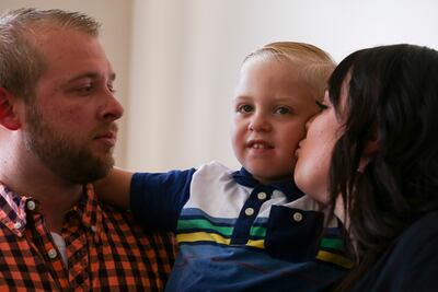 Tyler Farrell, left, holds son Lindon, 4, while Angela Farrell kisses him on the cheek during a ceremony in which the Farrells received the keys to their new home in Layton on Thursday, July 18, 2019. Lindon was diagnosed with acute kidney failure at 3 mo