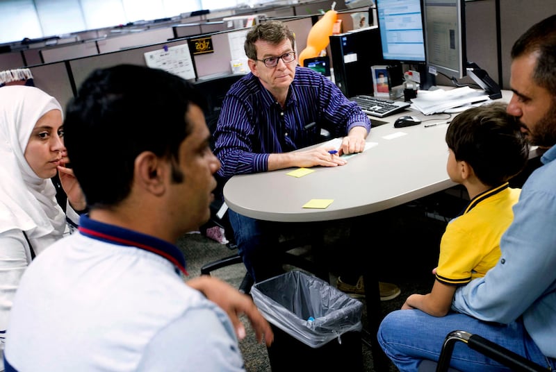 Refugee eligibility specialist Sefik Feukic, center, explains what refugee services are available to the Hamad family, as Khalid Al Hachami, second from left, translates, at the Utah Department of Workforce Services office in Salt Lake City on May 26, 201