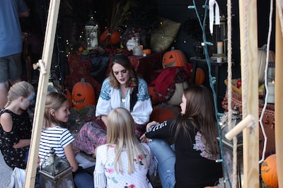 A fortuneteller interacts with some of Evermore's younger guests on Evermore's opening day, Sept. 29, 2018.