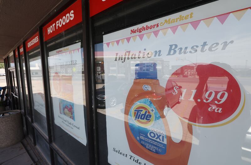 Signs advertising inflation buster products appear in windows at Neighbors Market in North Salt Lake on Wednesday, Aug. 10, 2022.
