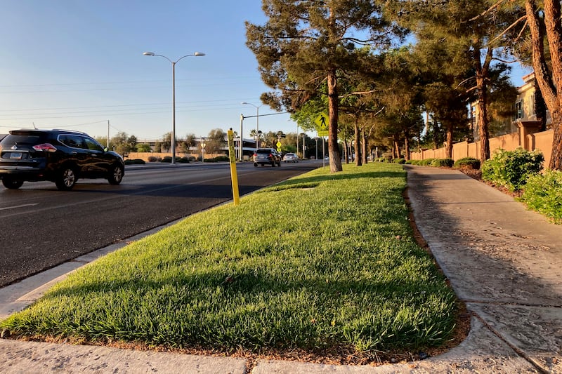 Traffic passes a grassy landscape on Green Valley Parkway in suburban Henderson, Nev., on April 9, 2021.