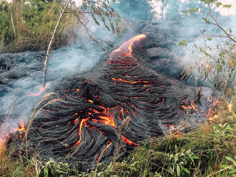 This Oct. 30, 2014 photo provided by the U.S. Geological Survey shows lava flow burning vegetation near the town of Pahoa on the Big Island of Hawaii. The Hawaii National Guard is deploying troops to a rural Hawaii town as lava makes a slow crawl toward a