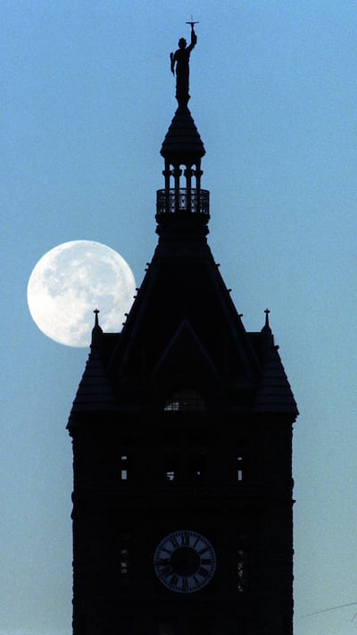FILE - The SLC city county building silhoutted against the moon set.