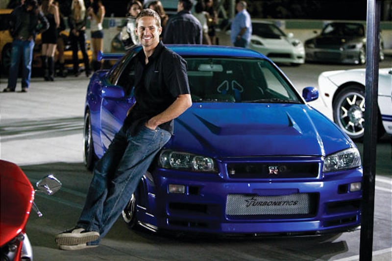 Paul Walker leans against a Nissan Skyline GTR in the fourth chapter of the franchise built on speed — "Fast & Furious."