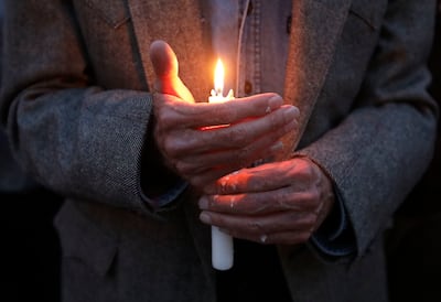 A man holds a candle during a vigil and prayer service for all those impacted by the shooting at the Tree of Life Synagogue in Pittsburgh, outside of Chabad Lubavitch of Utah in Salt Lake City on Monday, Oct. 29, 2018.