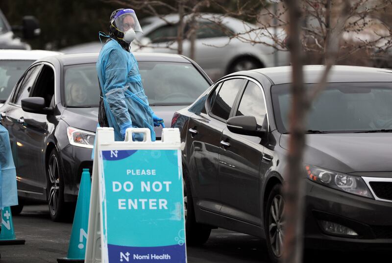 A medical worker tests people for COVID-19 outside of the Draper Senior Center.