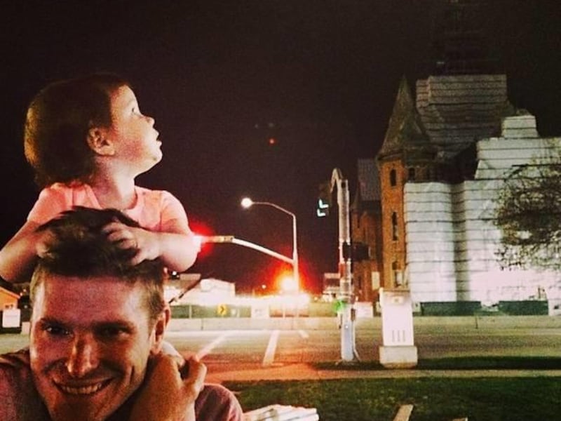 Blogger Stephanie Nielson's husband, Christian Nielson, smiles while the Nielson's daughter, Charlotte, looks at the Provo City Center Temple.