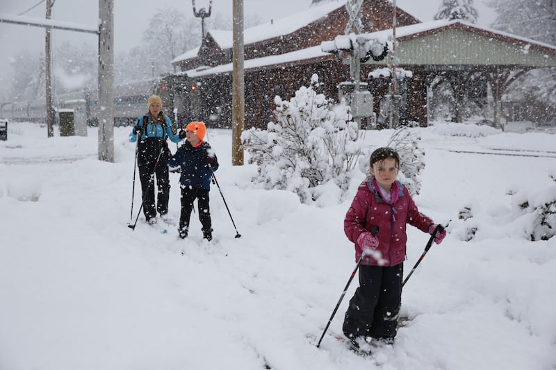 Beth Reilly, background, cross country skies with her two children, Noah, 7, in the middle, and Annelies, 5, during a snowstorm in Waterbury, Vt..