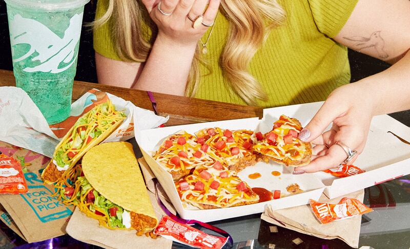 A girl eating Taco Bell’s Mexican Pizza.