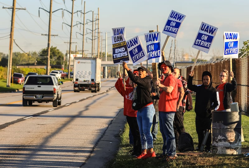 United Auto Workers, including Joseph Burch, wearing a mask, hold signs while on strike at the Stellantis Toledo Assembly Complex.