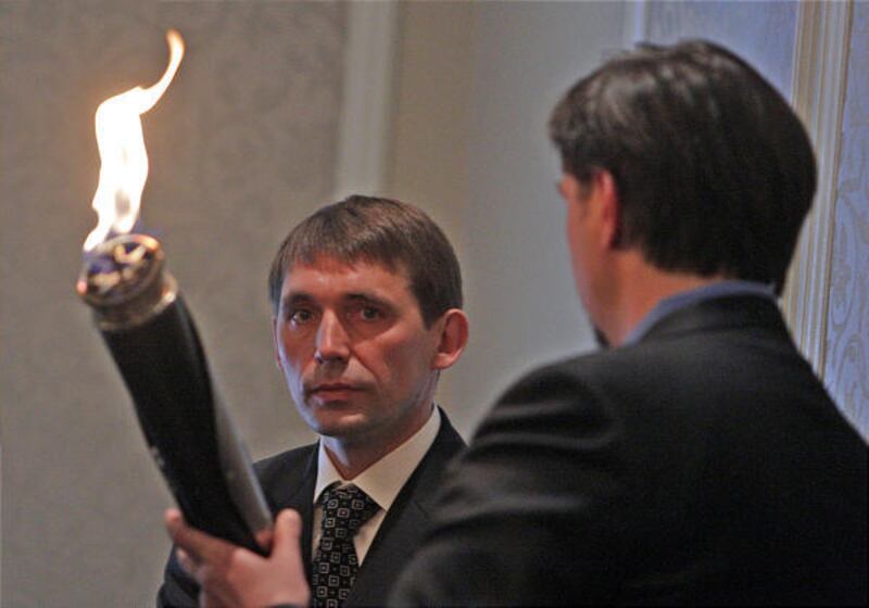 Mykola Tochytskyi, consul general of Ukraine, is handed a torch by Jonathan Freedman at the Alta Club for a ceremony marking the 75th anniversary of genocide in the Ukraine.