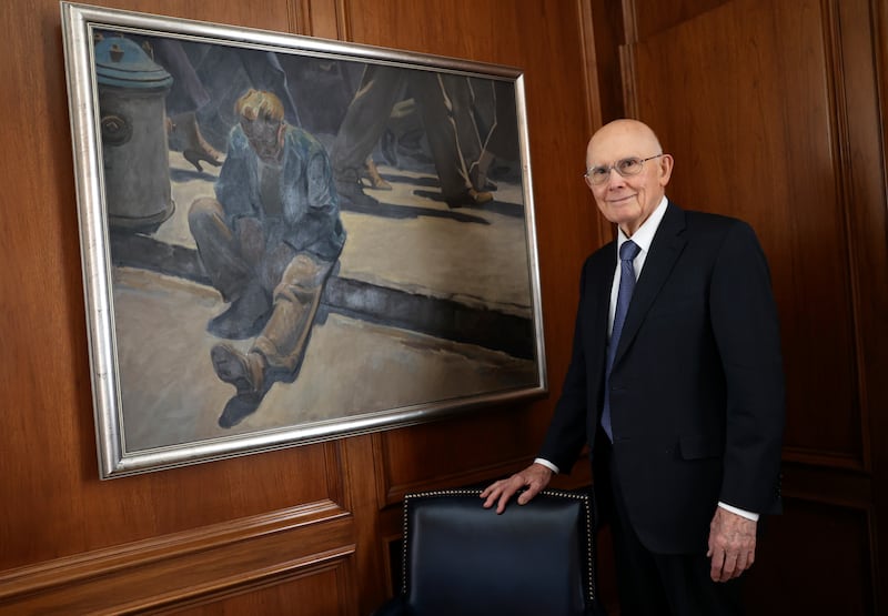 President Dallin H. Oaks poses by a print of Maynard Dixon’s “Forgotten Man” in his office in the Church Office Building.