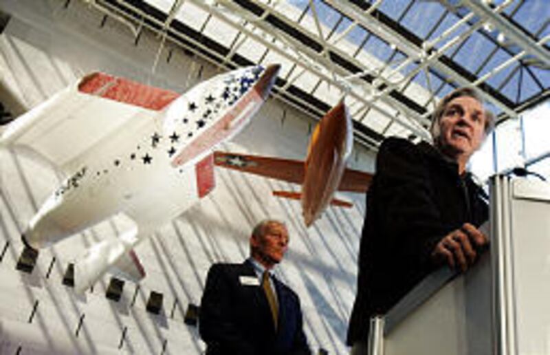 Burt Rutan, right, design engineer of SpaceShipOne, speaks at its induction into the Smithsonian's National Air and Space Museum.