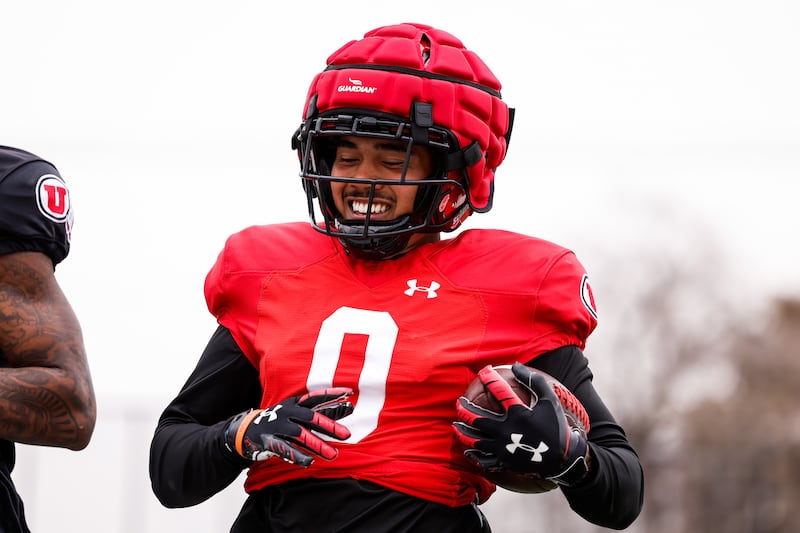 Utah freshman receiver Mikey Matthews smiles while carrying the ball during spring camp last month.