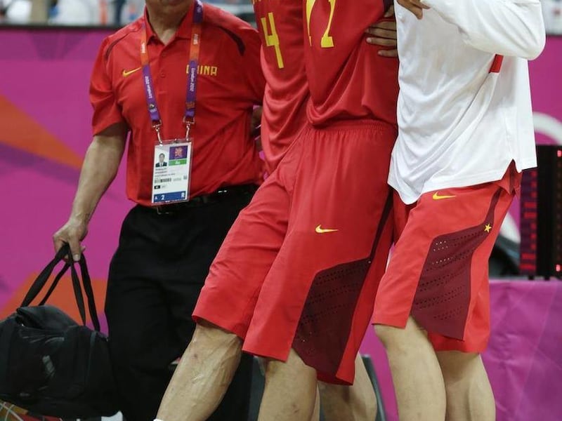 China's Yi Jianlian is helped off the court after an injury during a men's basketball game against Australia at the 2012 Summer Olympics, Thursday, Aug. 2, 2012, in London.