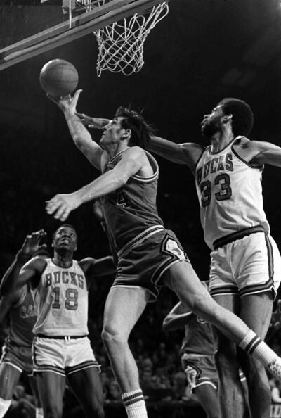 Chicago Bulls' Jerry Sloan (4) glides between the baseline and Milwaukee Bucks' Kareem Abdul-Jabbar (33) for two points, Feb. 16, 1974, in Milwaukee.