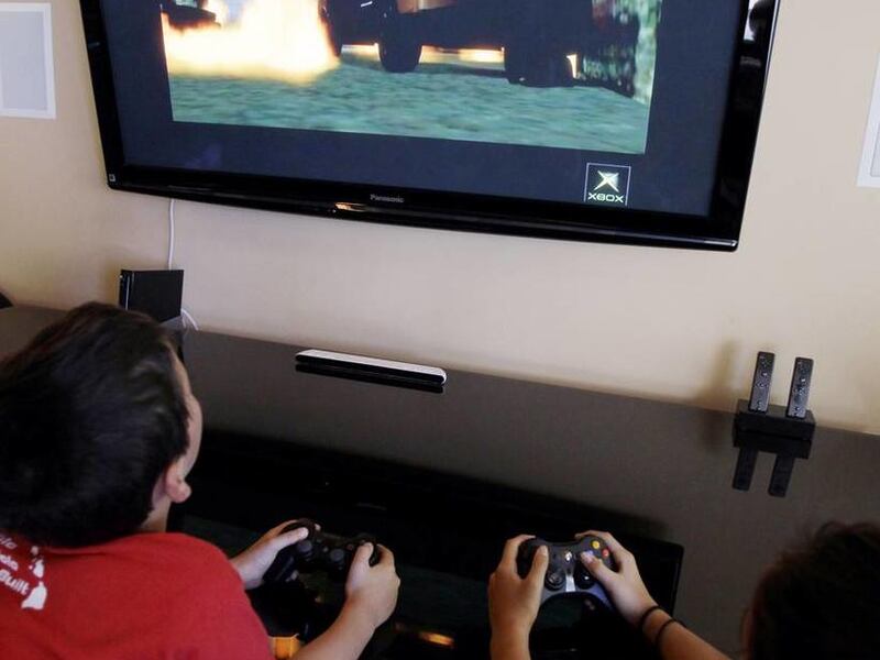 JT Taga-Anderson, 9, left, and Mika Taga-Anderson, 13, play Grand Theft Auto IV in Los Altos, Calif.