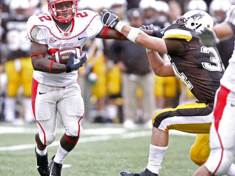 New Mexico's Paul Baker stiff-arms Wyoming's Sean Claffey.