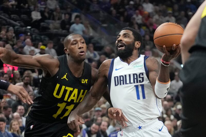 Dallas Mavericks guard Kyrie Irving (11) drives as Utah Jazz guard Kris Dunn (11) defends during an NBA basketball game.