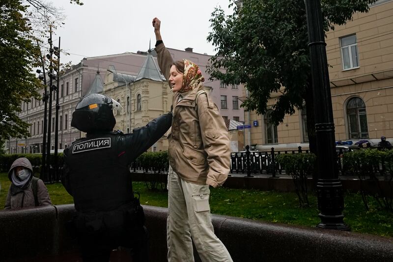 A police officer detains a demonstrator during a protest against a partial mobilization in Moscow, on Saturday, Sept. 24, 2022.