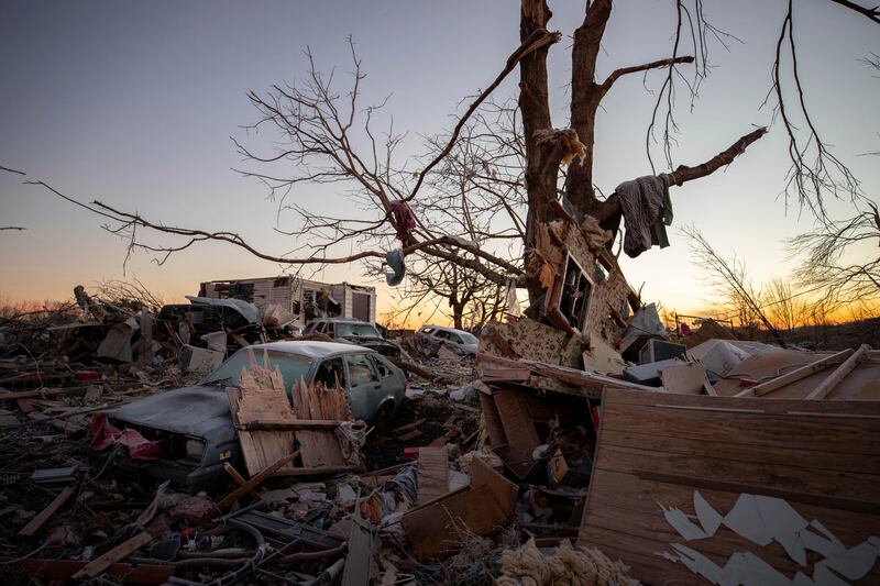 A car sits amid debris from a house destroyed by a tornado in Kentucky.