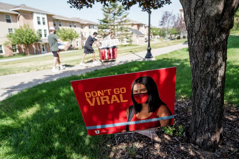 A lawn sign encourages wearing a mask as students move into dormitories at the University of Utah in Salt Lake City on Tuesday, Aug. 18, 2020.