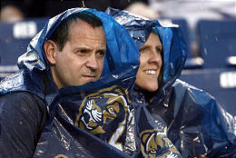 BYU fans Jeff and Stephanie Weber of Highland endure the downpour on Saturday afternoon in LaVell Edwards Stadium.<BR>
