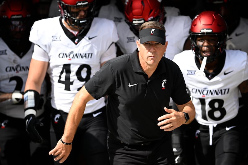 Cincinnati head coach Scott Satterfield, center, leads the team onto the field before a game against Central Florida, Saturday, Oct. 12, 2024, in Orlando, Fla.