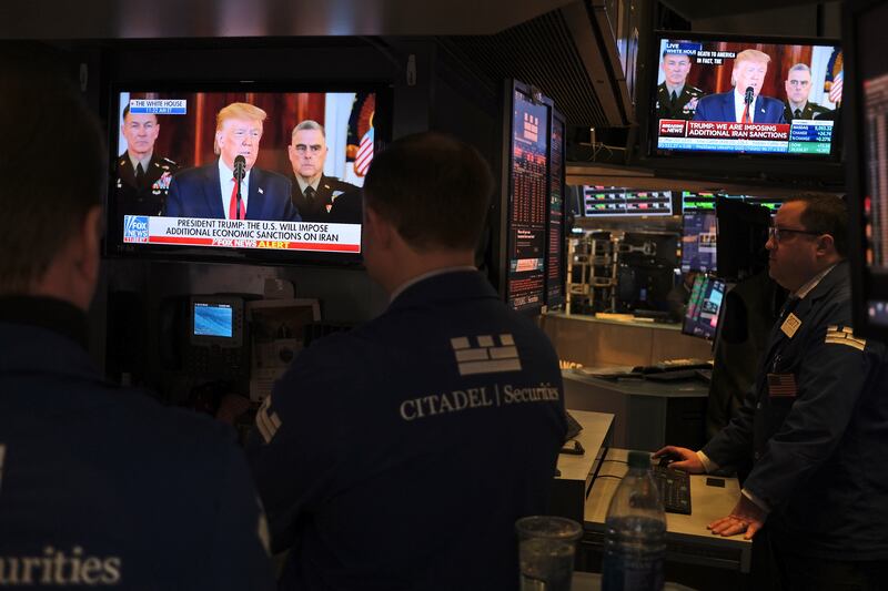 In this Jan. 8, 2020, photo traders pause to watch a televised speech by President Donald Trump as they work the floor of the New York Stock Exchange in New York.