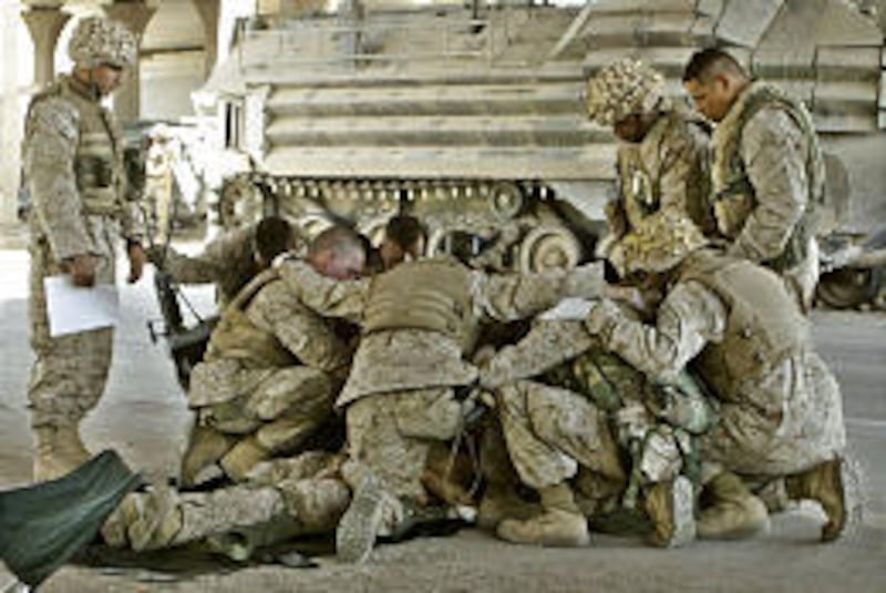 Doctors, corpsmen and Marines pray over a fallen Marine comrade at a first aid point after he died from wounds he suffered in fighting in Fallujah, Iraq, on Thursday.