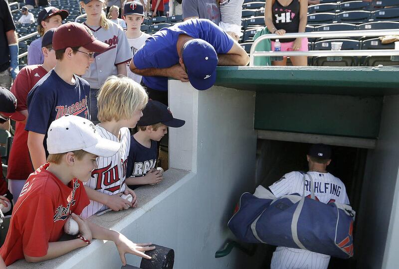 Fans watch as Minnesota Twins' Dan Rohlfing enters the dugout hallway after an exhibition spring training baseball game against the Boston Red Sox in Fort Myers, Fla., Friday, March 29, 2013. The Twins won 8-3.