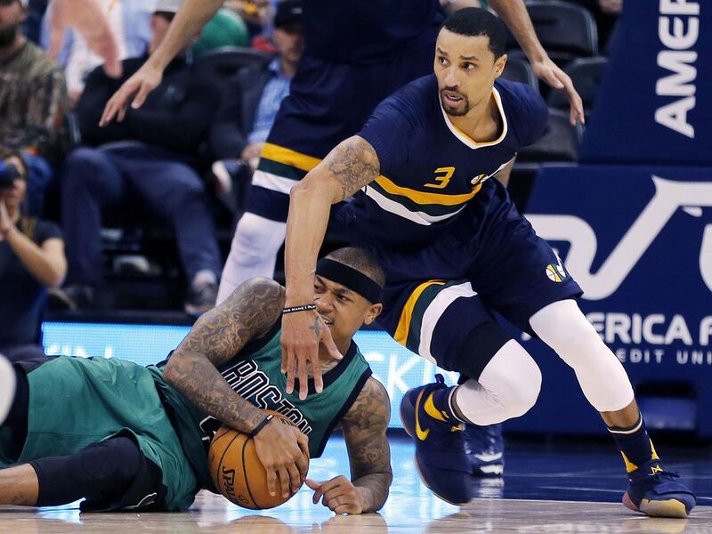 Boston Celtics guard Isaiah Thomas (4) goes to the floor to grab the bal with Utah Jazz guard George Hill (3) above during NBA basketball in Salt Lake City on Saturday, Feb. 11, 2017.