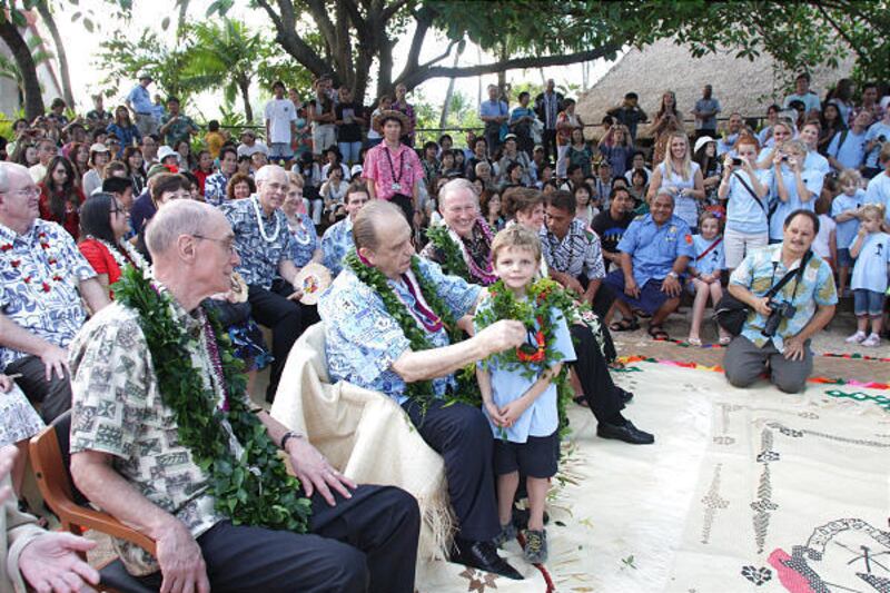 In Hawaii to rededicate the Laie Hawaii Temple on Sunday, LDS Church President Thomas S. Monson visits the Polynesian Cultural Center on Friday. During a visit to the center's Samoan village, he presents a lei to Cameron Orme, 6, of Provo. President Henry