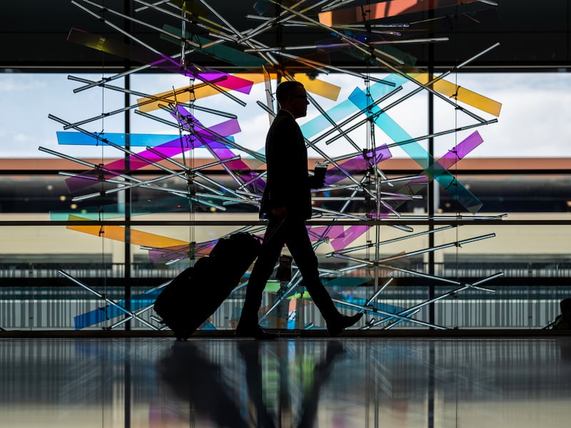 A traveler walks past “The Falls” sculpture at Salt Lake City International Airport in Salt Lake City.