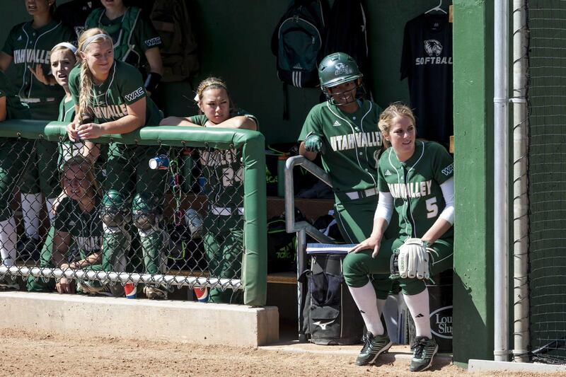 Multiple players from the UVU softball team look on from the dugout during a recent game at Wolverine Field in Orem.