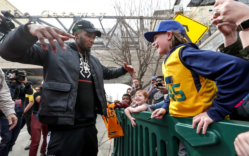 Donovan Mitchell, of the Utah Jazz, embraces his fans after event where the pedestrian bridge spanning 100 south, at The Gateway in Salt Lake City, is named after him on Tuesday, March 26, 2019.
