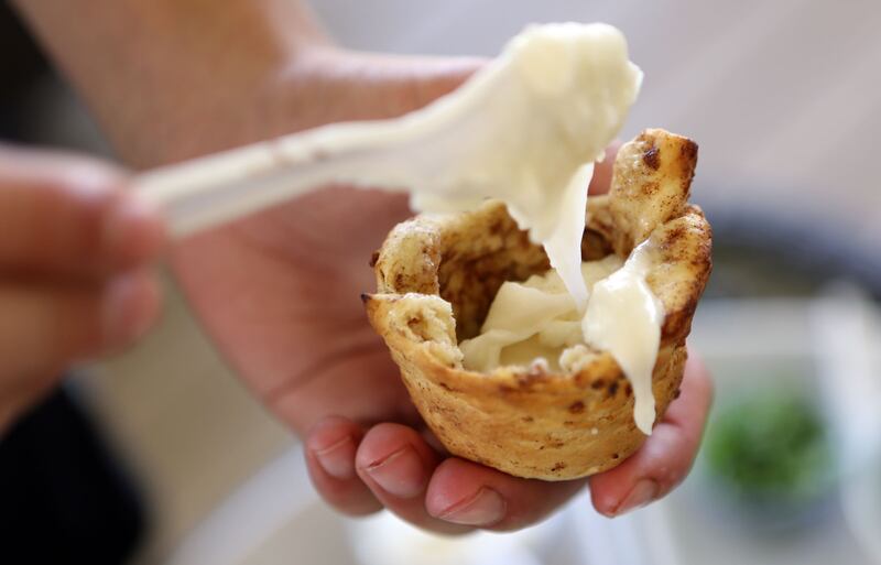 Spencer Harrison fills a cinnamon roll shell with frosting while demonstrating how to use a Wolf ‘em Stick, a product he and his brother Tanner are making and selling that is used to cook tasty treats over a campfire, in South Jordan on Saturday, June 29, 2013.