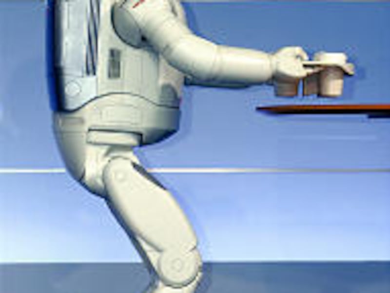 Honda Motor Co.'s new humanoid robot ASIMO carries a tray of drinks to a table during a demonstration at Honda's Tokyo head office Tuesday.