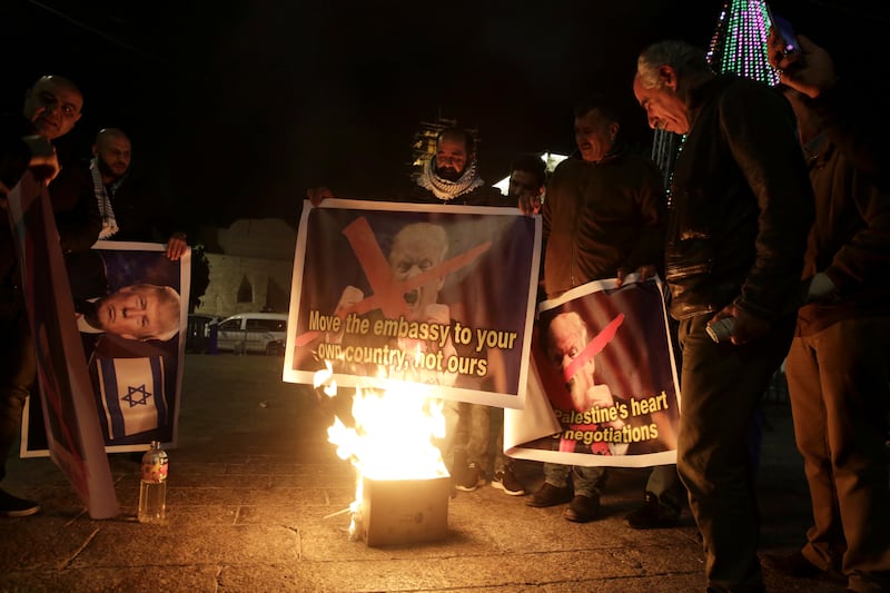 Palestinian burn a poster of the U.S. President Donald Trump during a protest in Bethlehem, West Bank, Tuesday, Dec. 6, 2017. President Trump forged ahead Tuesday with plans to recognize Jerusalem as Israel's capital despite intense Arab, Muslim and Europ