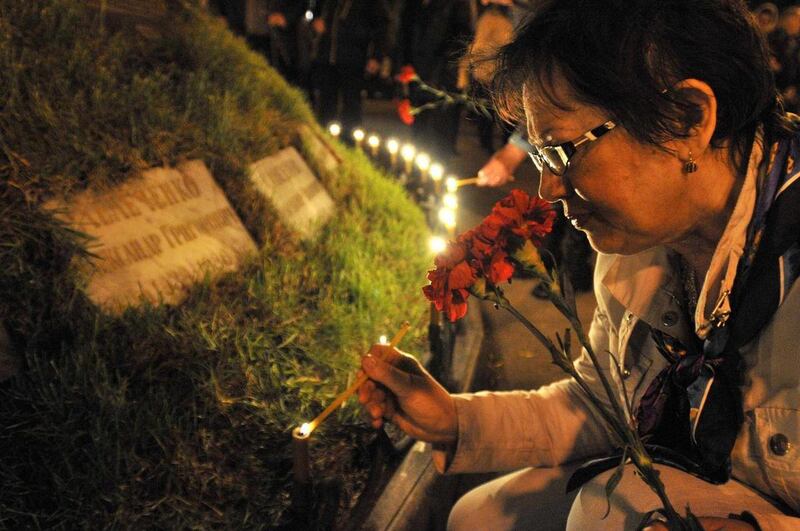 Woman lights candles to honor the memory of the victims of the Chernobyl disaster in Kiev, Ukraine,Thursday, April 26, 2012.