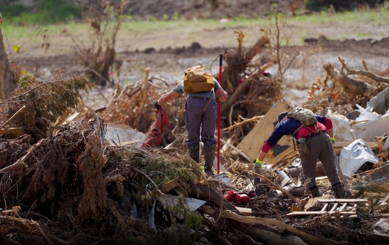 Volunteers gather items from the Guadalupe River in Hunt, Texas, on July 26, 2025, following the severe flooding in central Texas on July 4, 2025.
