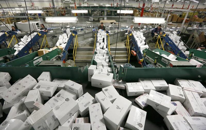 USPS employees sort packages at the Priority Mail Center Tuesday, Dec. 9, 2014, in Salt Lake City.